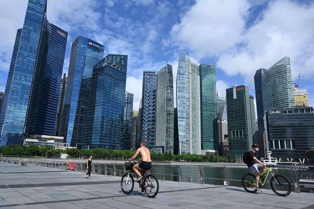 Cyclists ride their bicycles along the promenade at Marina Bay. Singapore rose by two points in the EIU cost of living report. Photo: AFP