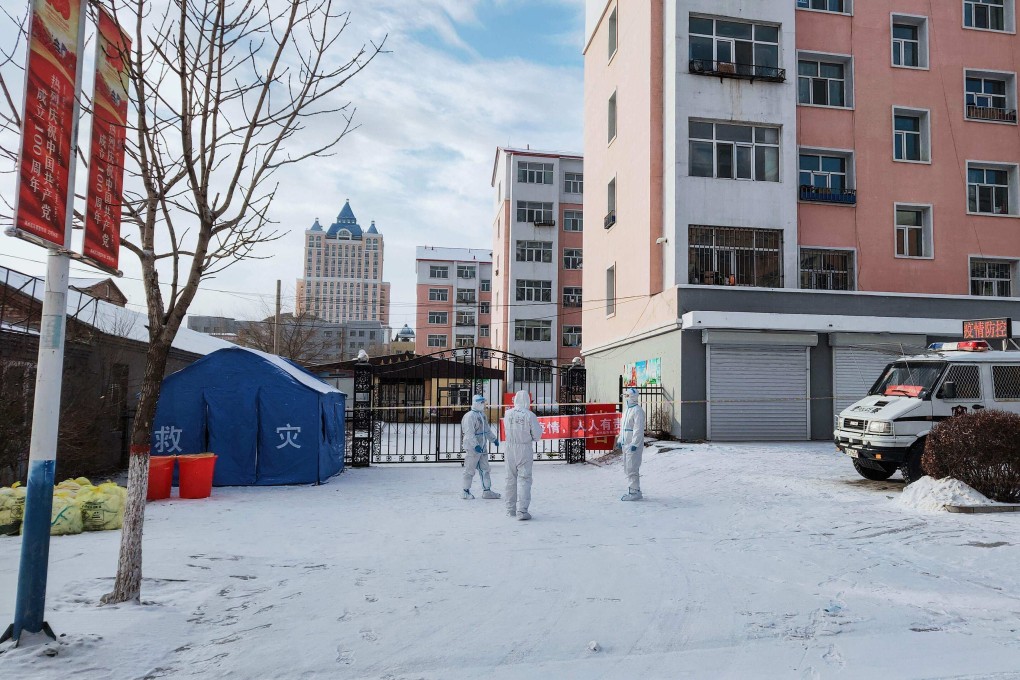 Health workers stand guard outside a restricted residential area in Manzhouli. Photo: AFP