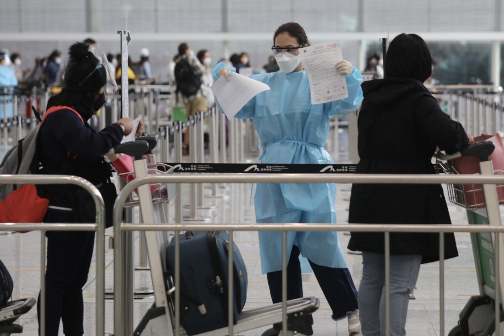 A staff member checks arriving passengers’ health documents at Hong Kong International Airport. Photo: Xiaomei Chen
