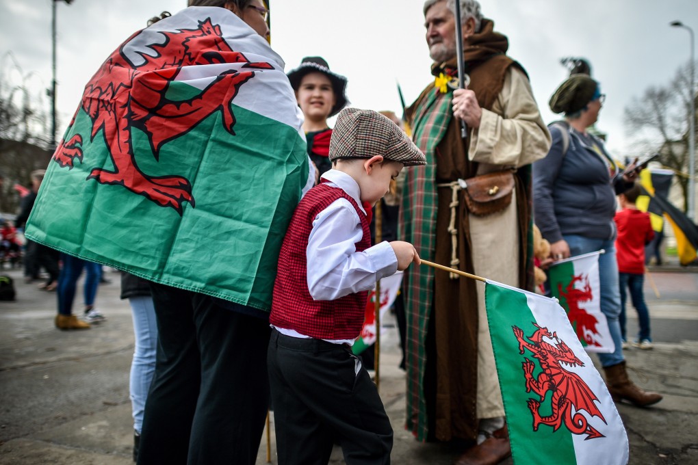 People wear traditional dress and carry the Welsh flag during a St David’s Day Parade in Cardiff in 2019. With a rise in Welsh pride has come renewed interest in the Welsh language, which the English repressed for centuries. Photo: Getty Images