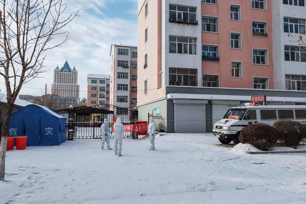 Health workers stand guard outside a residental area under lockdown in Manzhouli. Photo: AFP