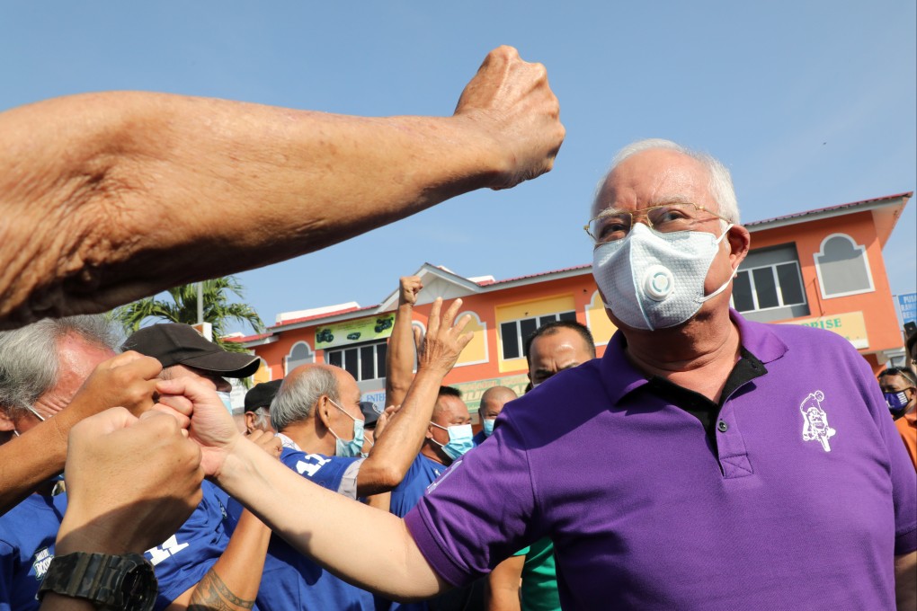 Former Malaysian prime minister Najib Razak gives a fist bump to a supporter on the campaign trail. Photo: Reuters