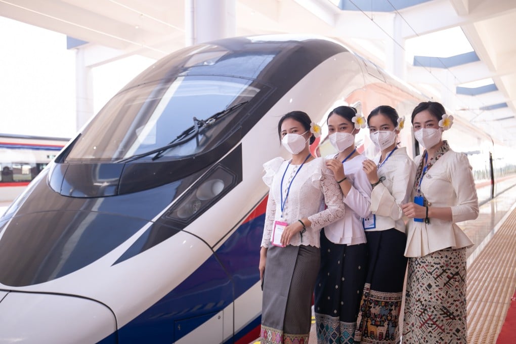 Staff pose for photos with one of the new bullet trains at the Vientiane railway station in Laos on Thursday. Photo: Xinhua
