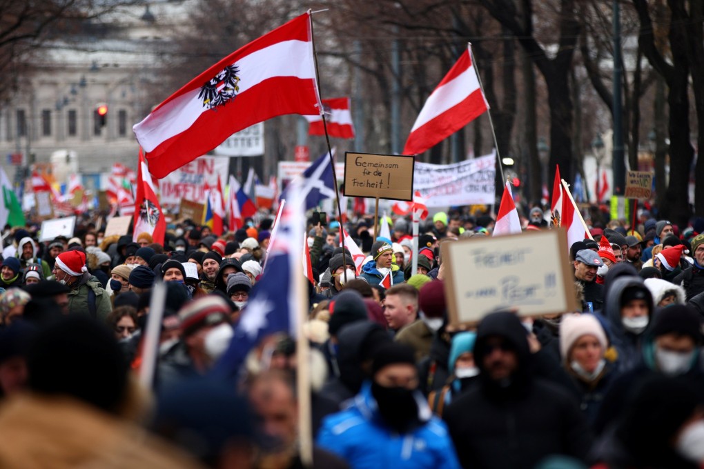 Protesters hold flags and placards as they march against coronavirus restrictions and the mandatory vaccination in Vienna, Austria on Saturday. Photo: Reuters
