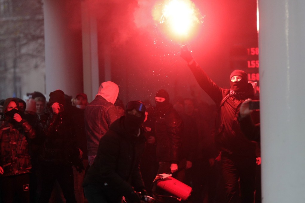 Protesters light flares during clashes at an anti-coronavirus measures protest in Brussels, Belgium on Sunday. Photo: EPA-EFE