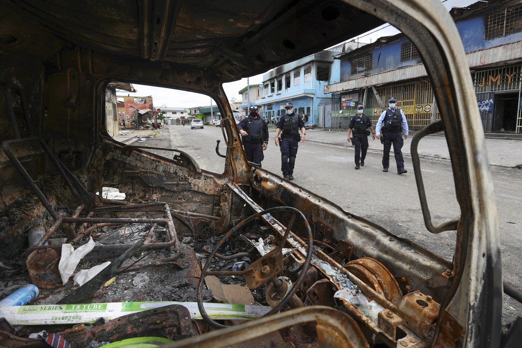 Australian Federal Police inspect burnt out areas of Chinatown in Honiara on November 30. Photo: AP