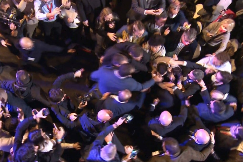A man attempts to grab French far-right media pundit and presidential candidate Eric Zemmour in Villepinte, near Paris on Sunday. Photo: Conception et réalisation / Olivier Ubéda, pour Eric Zemmour / AFP