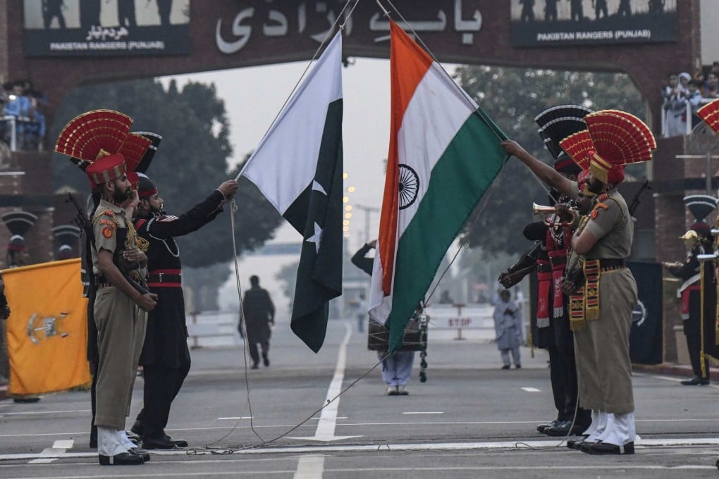 Indian and Pakistani border forces lower their respective flags at a daily ceremony held at the India-Pakistan Wagah Border Post. Photo: AFP