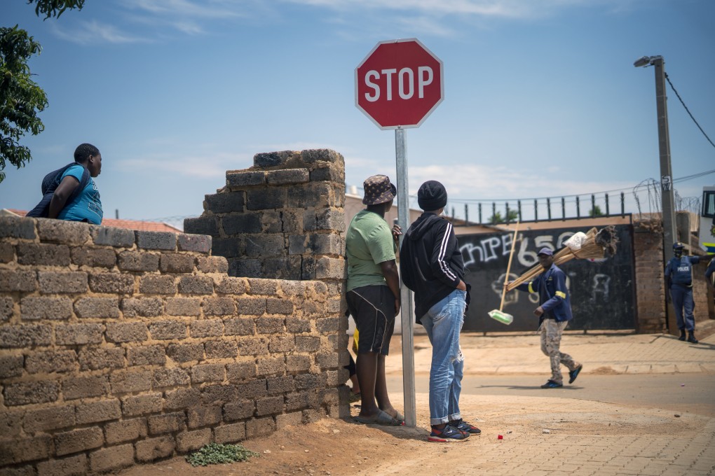 Residents stand in the streets of Lawley, South Africa, during a visit by local government officials for the launch of the Vooma vaccination program against Covid-19. Photo: AP
