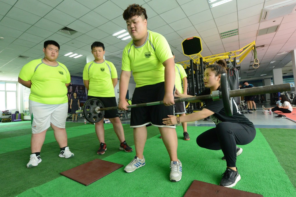 Obese Chinese students do exercise under the guidance of a coach at a summer camp in Zhengzhou, Henan Province of China. Photo: Getty