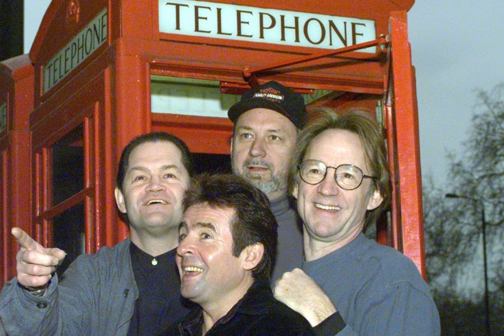 Members of The Monkees (from left, Micky Dolenz, Davy Jones, Mike Nesmith and Peter Tork) pose in front of a telephone booth in London in January 1997. Photo: AP