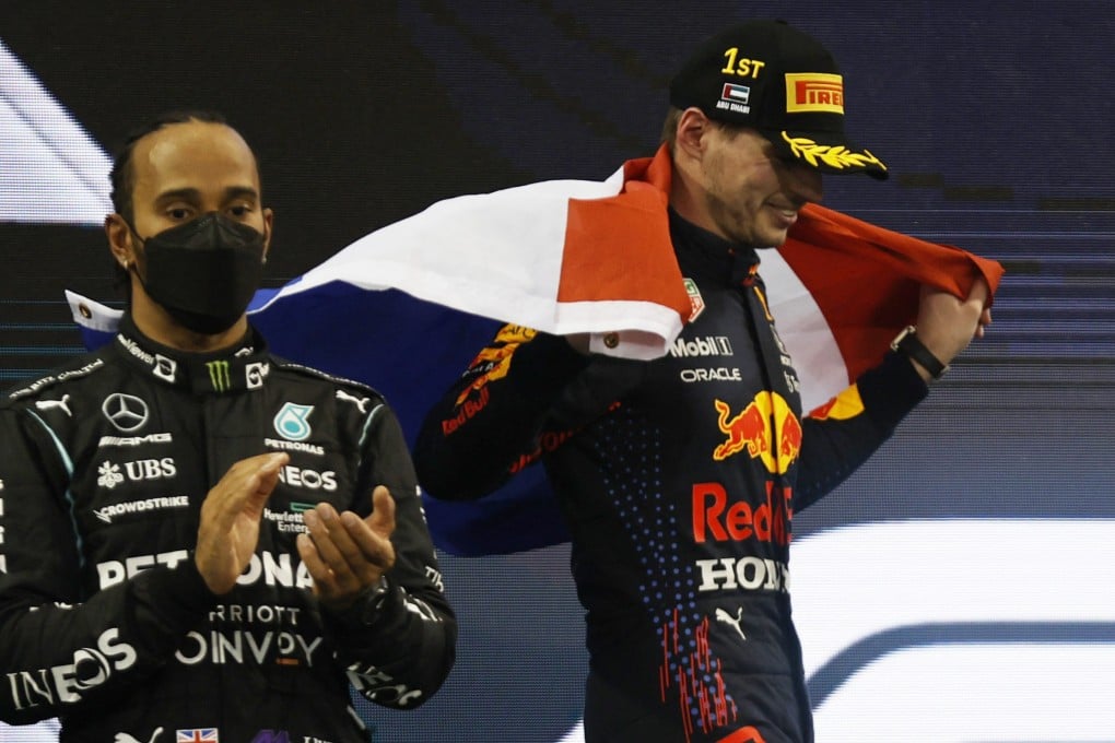 Max Verstappen celebrates winning the race and the world championship as Lewis Hamilton looks on after finishing second. Photo: Reuters