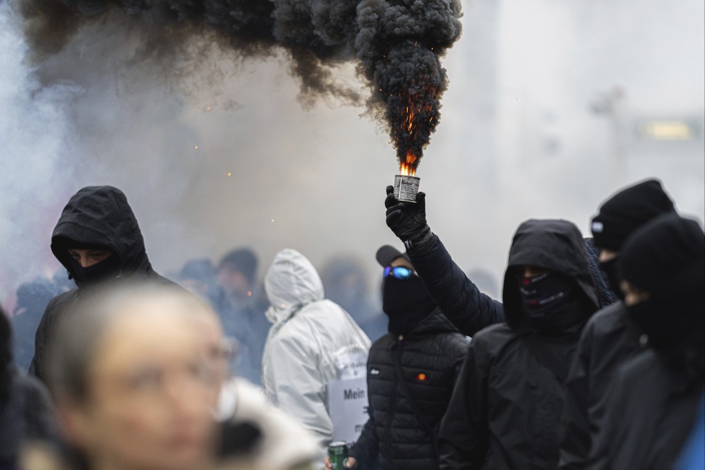 Protesters light flares during a demonstration against coronavirus restrictions in Vienna, Austria on Saturday. Photo: AP