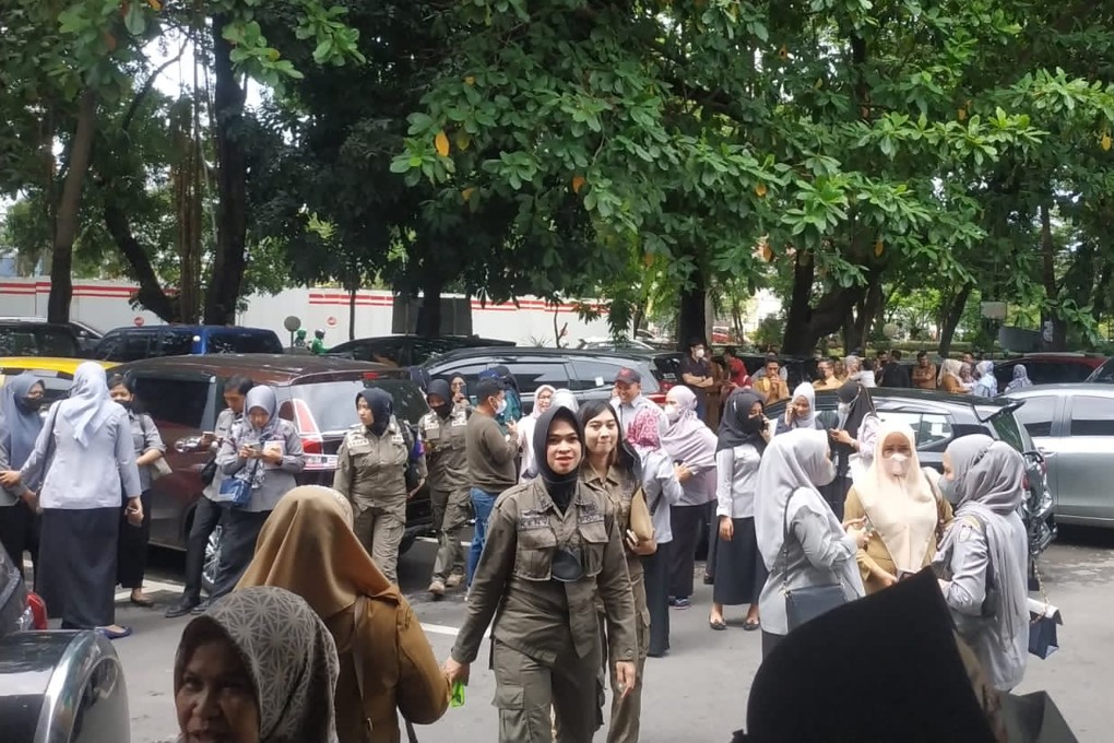 People wait outside after evacuating a government building following an earthquake in Makassar, South Sulawesi, Indonesia, on December 14. Photo: AP