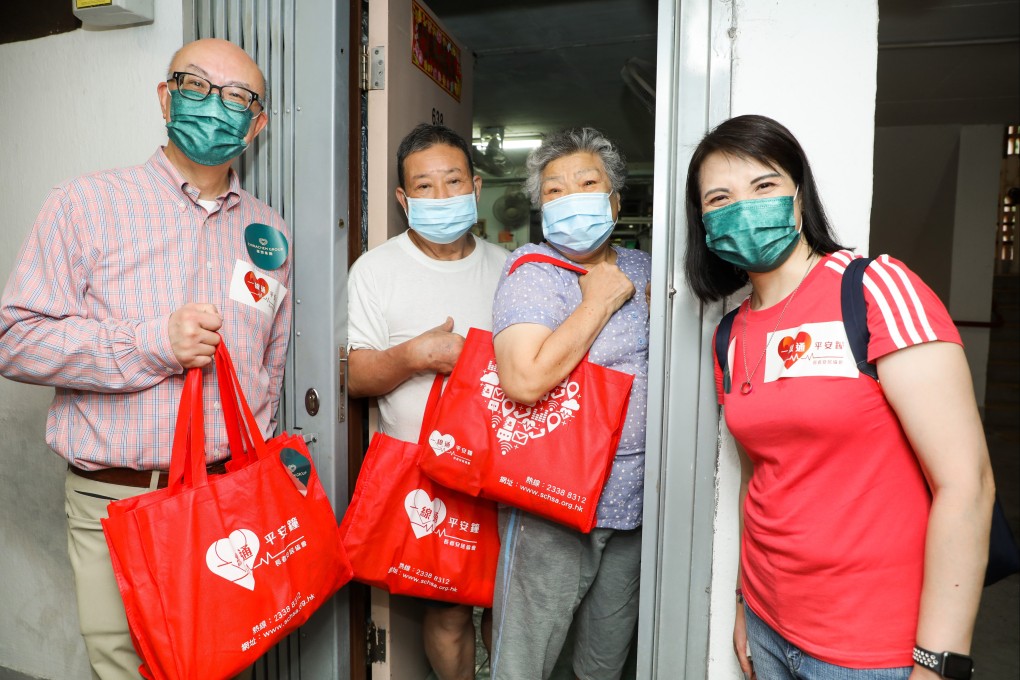 Chinachem Group executive director and CEO Donald Choi (left) and Winnie Woo (right), of the Nina Hotel Tsuen Wan West, take part in a home visit to an elderly family. Photo: Handout