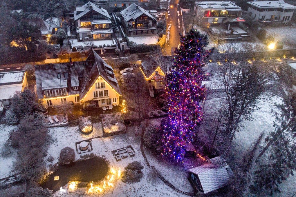 A giant tree is decorated with Christmas lights in the village of Falkenstein. Germany eyeing new restrictions in view of Omicron. Photo: AP