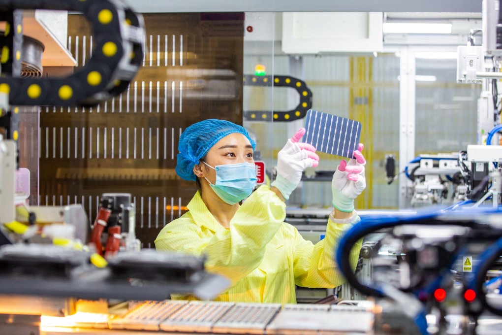 An employee inspects solar photovoltaic modules at a factory in Haian, in China’s eastern Jiangsu province, on November 15. Photo: AFP