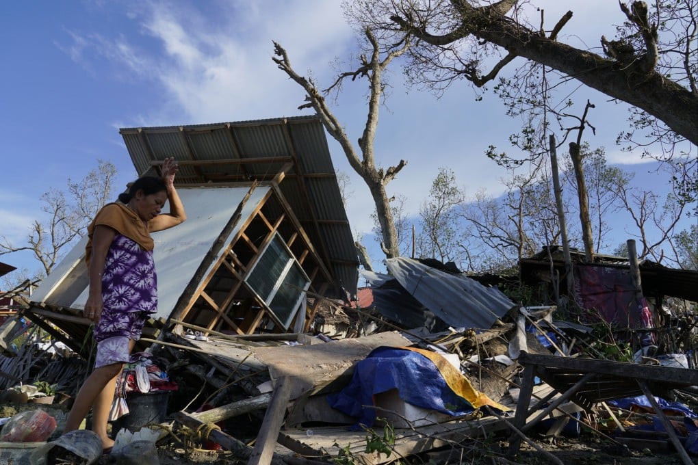 A woman salvages parts of her home damaged due to Typhoon Rai, in Talisay, Cebu province, Philippines. Photo: AP
