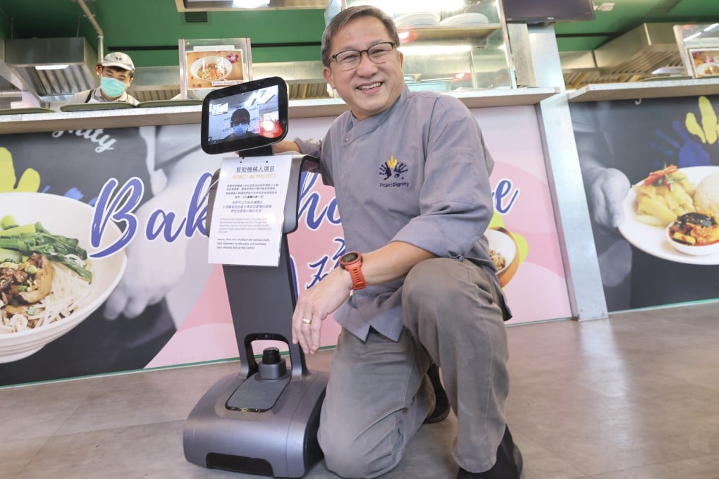 Dignity Kitchen founder Koh Seng Choon (right) with paraplegic Eddie Lau (on the tablet screen) who operates Temi, the robot, remotely. Photo: May Tse
