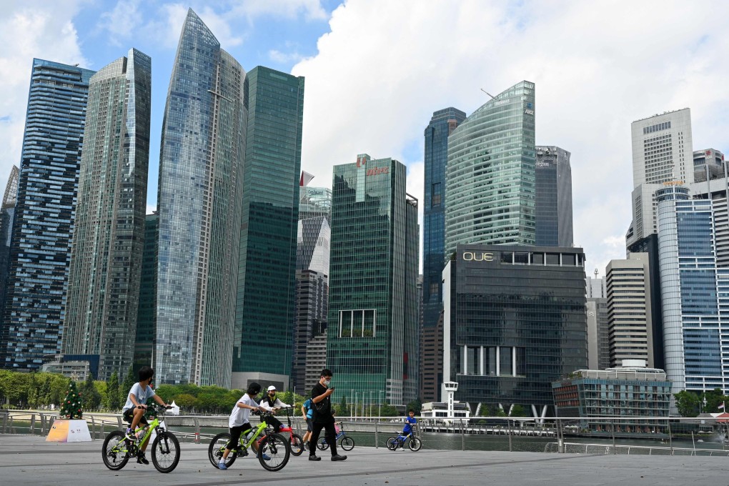 People ride bicycles along the promenade at Marina Bay in Singapore, as the city state learns to live with the virus. Photo: AFP