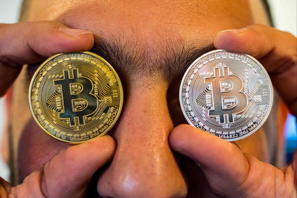 A person holding a visual representation of the digital crypto-currency Bitcoin. Photo: AFP