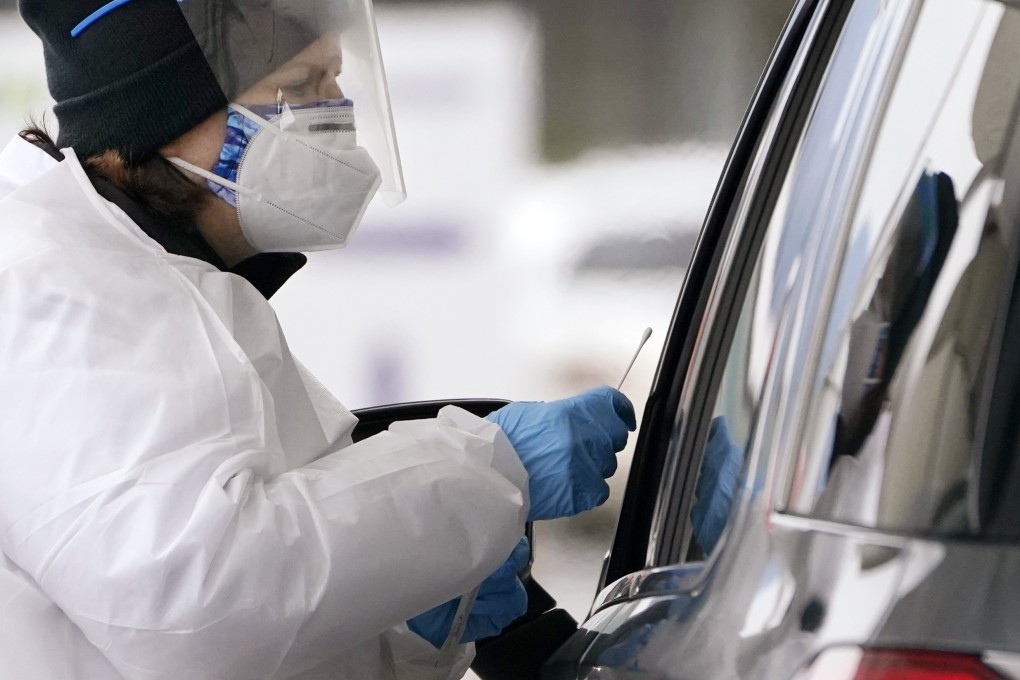 A Covid-19 testing specialist reaches forward to swab a driver at a coronavirus testing location in Bellingham, Washington, on Dec 21. Photo: AP