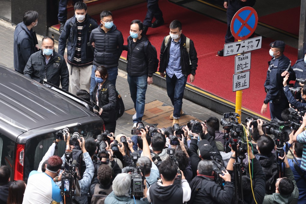 National security police escort Stand News acting editor-in-chief Patrick Lam from the outlet’s Kwun Tong office in handcuffs. Photo: May Tse