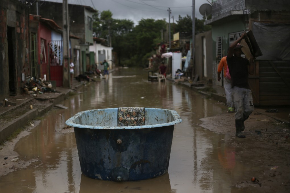 A bathtub is used as a boat in a flooded street in Itapetinga, Bahia state, Brazil on December 28. Photo: AP