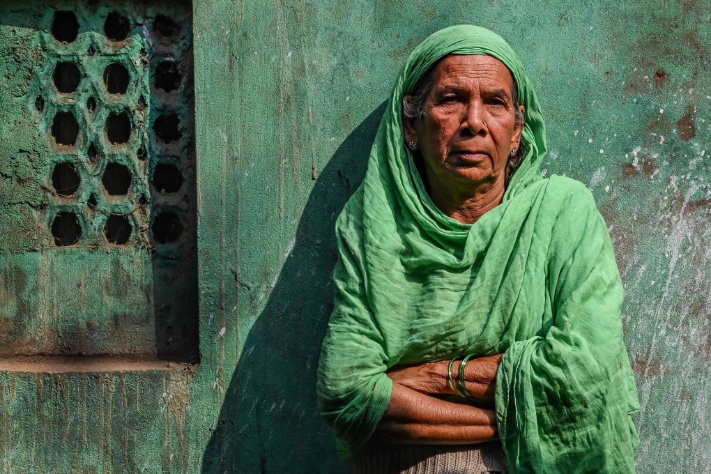 Sultana Begun poses for a photo near the cramped two-room hut where she lives in Kolkata. Photo: AFP