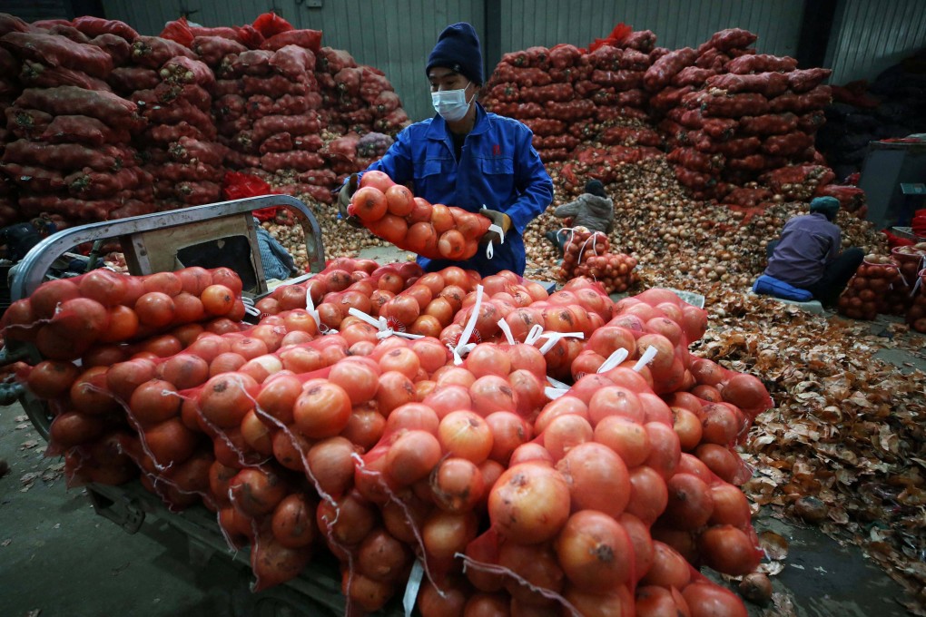 A vendor loads bags of onions at a market in Shenyang, in China’s Liaoning province, on December 9. Disruptions to supply chains have been less intense in East Asia compared to the US and elsewhere. Photo: AFP
