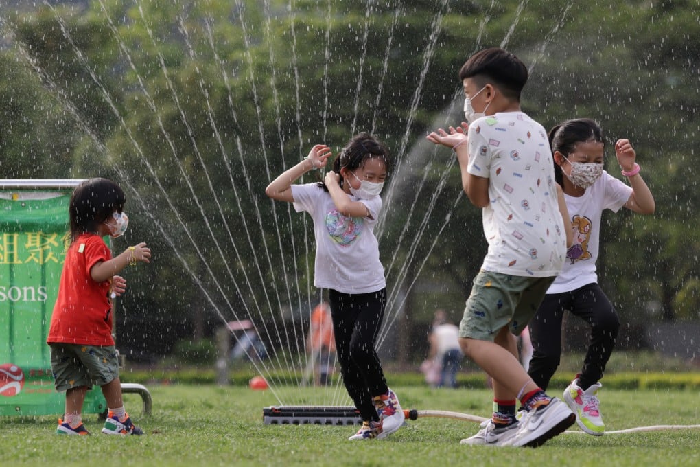 Children enjoy being drenched by sprinkler at the Velodrome Park in Tseung Kwan O in May. Photo: May Tse