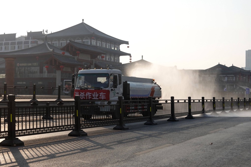 A truck sprays disinfectant on a street in locked down Xian. Photo: AFP