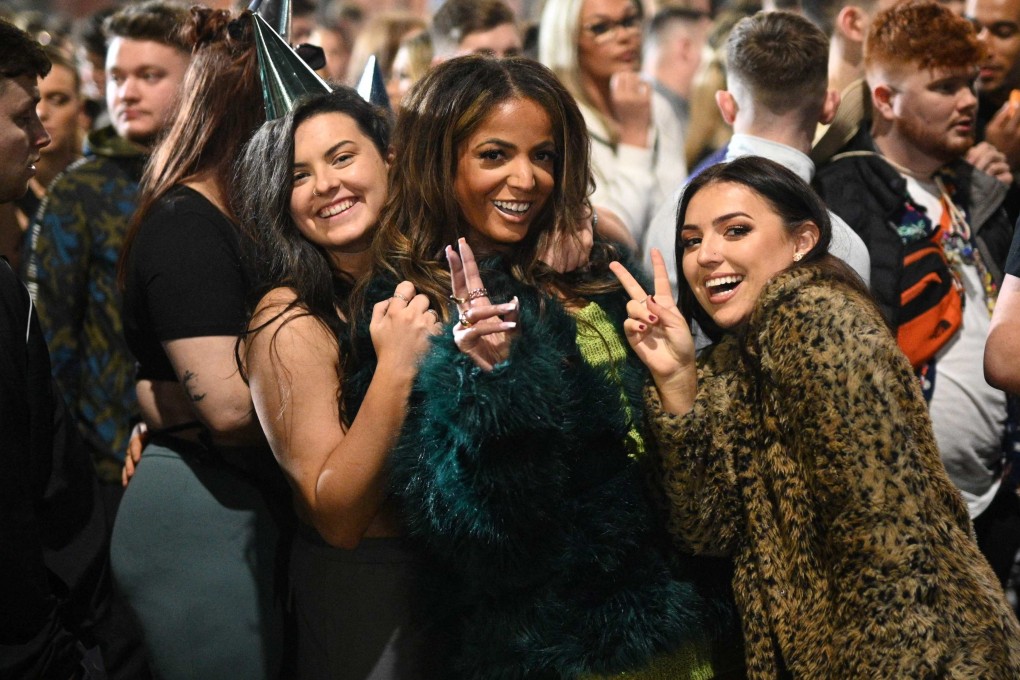 Revellers pose for a photo as they queue to enter a 10,000 capacity nightclub in Manchester, England on New Year’s Eve, 2021. England was the exception among the four UK nations in not imposing extra virus curbs over the festive period. Britain’s Prime Minister Boris Johnson urged people to get tested and be “sensible”. Photo: AFP