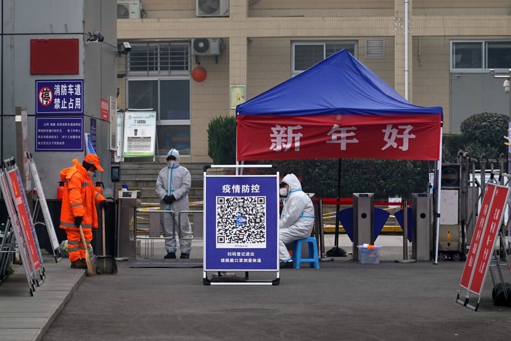 Workers in protective suits stand guard at the entrance of a residential compound in Xian. Photo: AFP