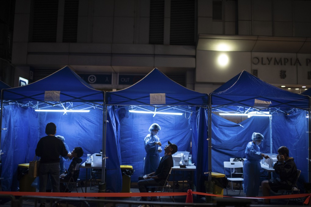 Health workers administer Covid-19 tests outside a building placed under lockdown in Hong Kong. Photo: Bloomberg
