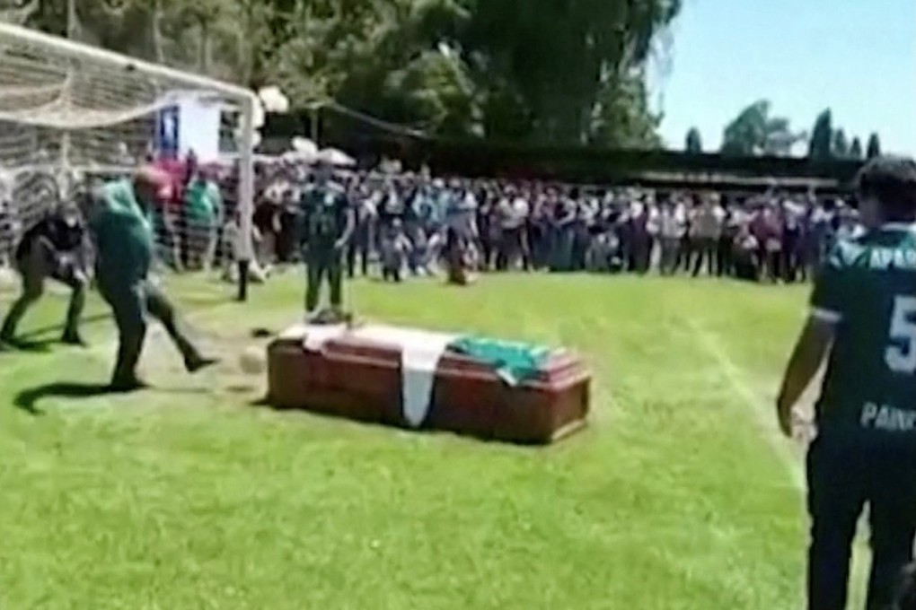 A man kicks a ball against the late player Jaime Escandar’s coffin during a final send off given by his Aparicion Paine team in Paine, Chile. Photo: Reuters