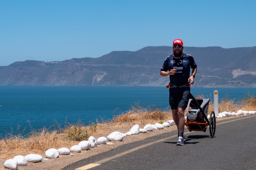 Jonas Deichmann pulls his supply trolley as he runs on a coastal road in Mexico. Photo: Jonas D/Markus W