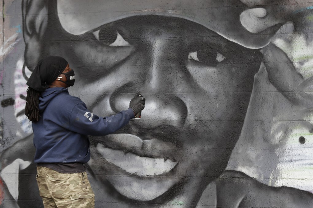 Artist Theo Ponchaveli paints a mural of the likeness of Ahmaud Arbery in Dallas, Texas, in May 2020. Photo: AP