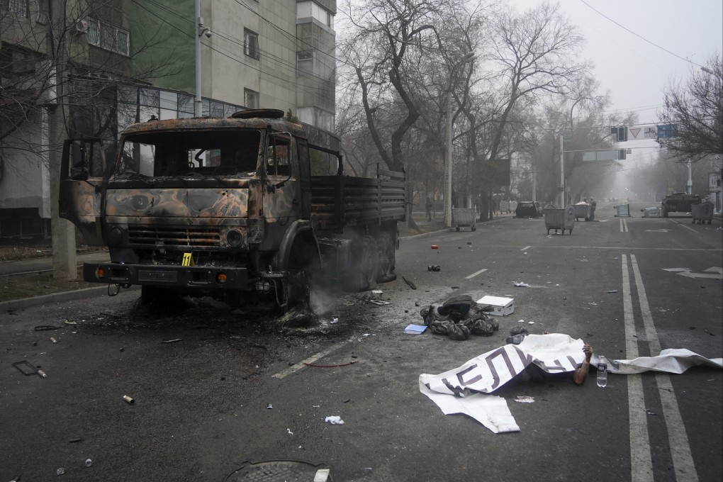 A body, covered by a banner, lays near a military truck burned during protests in Almaty, Kazakhstan in recent days. The Central Asian nation has experienced its worst street protests since gaining independence from the Soviet Union three decades ago, with reports of 164 people killed. Photo: AP