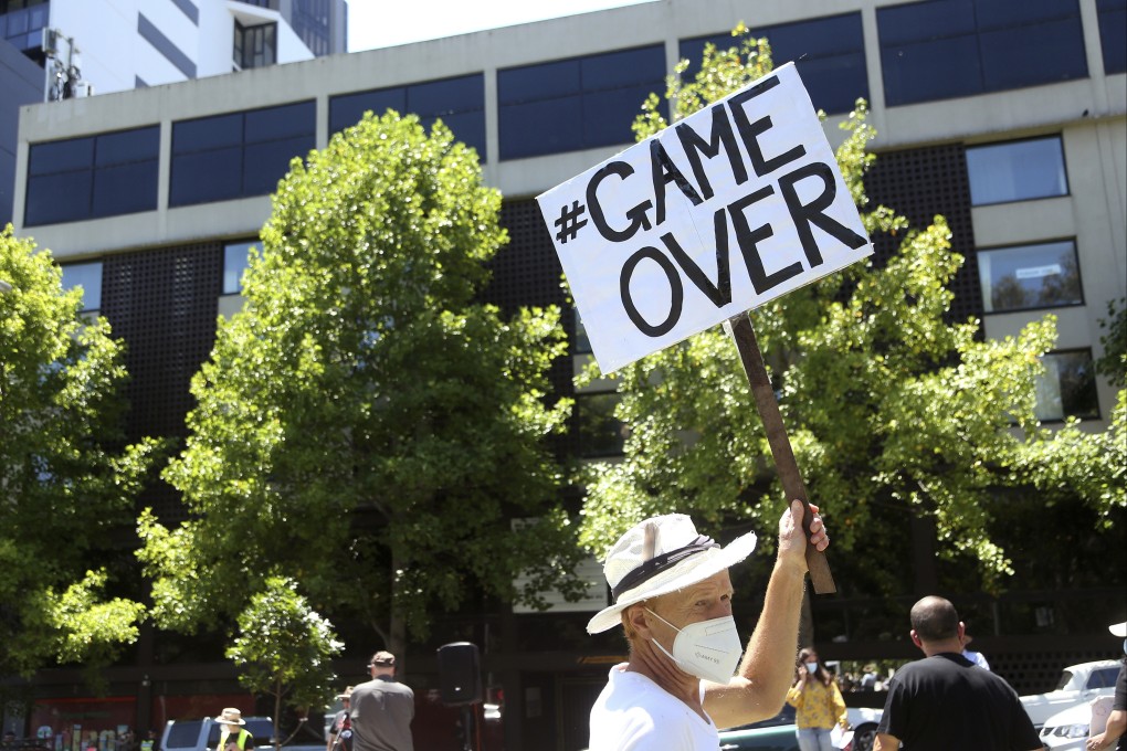 A protester holds a placard outside the Park Hotel, used as an immigration detention hotel where Djokovic is being held. Photo: AP