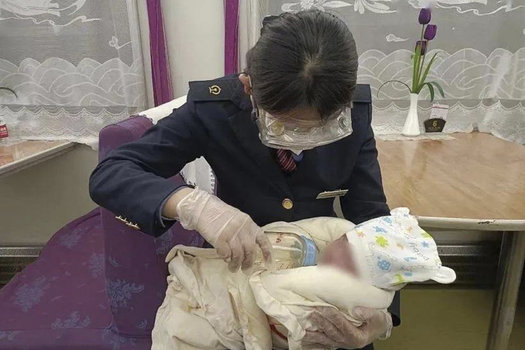 A train worker takes care of a baby who had been saved from a couple who bought the boy. Photo: Sohu