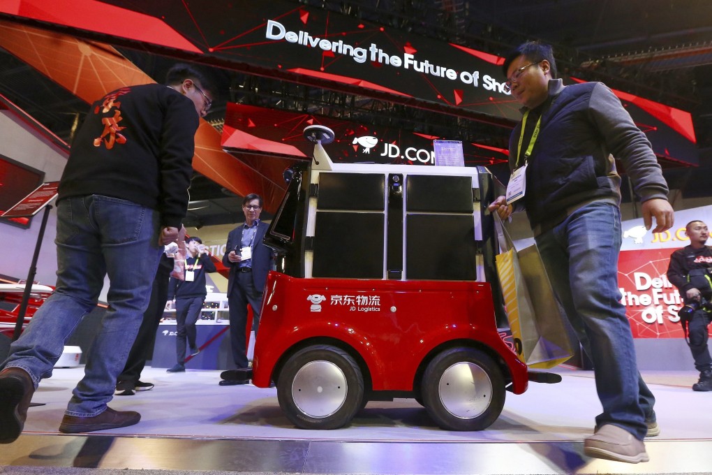 Attendees check out an autonomous delivery robot vehicle at the JD.com booth at CES International in Las Vegas in January 2019. Photo: AP