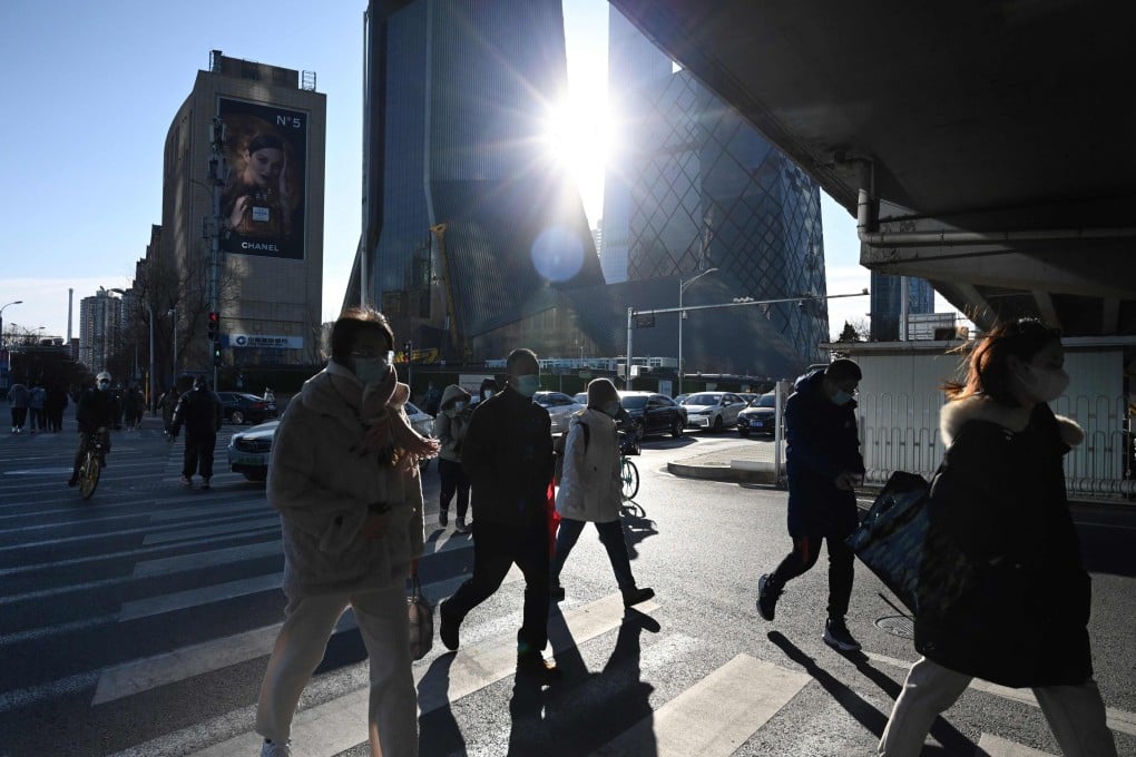 People cross a road in the central business district in Beijing on December 16, 2021. Photo: AFP
