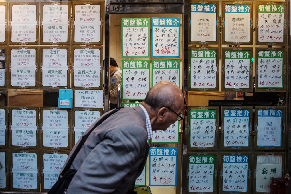 A man looks at residential property advertisements displayed in the window of an estate agency in North Point. Photo: Bloomberg