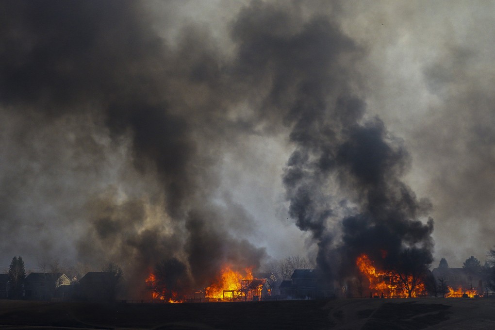 Two homes are seen in flames after wildfires swept through Louisville, Colorado, in December. Photo: TNS