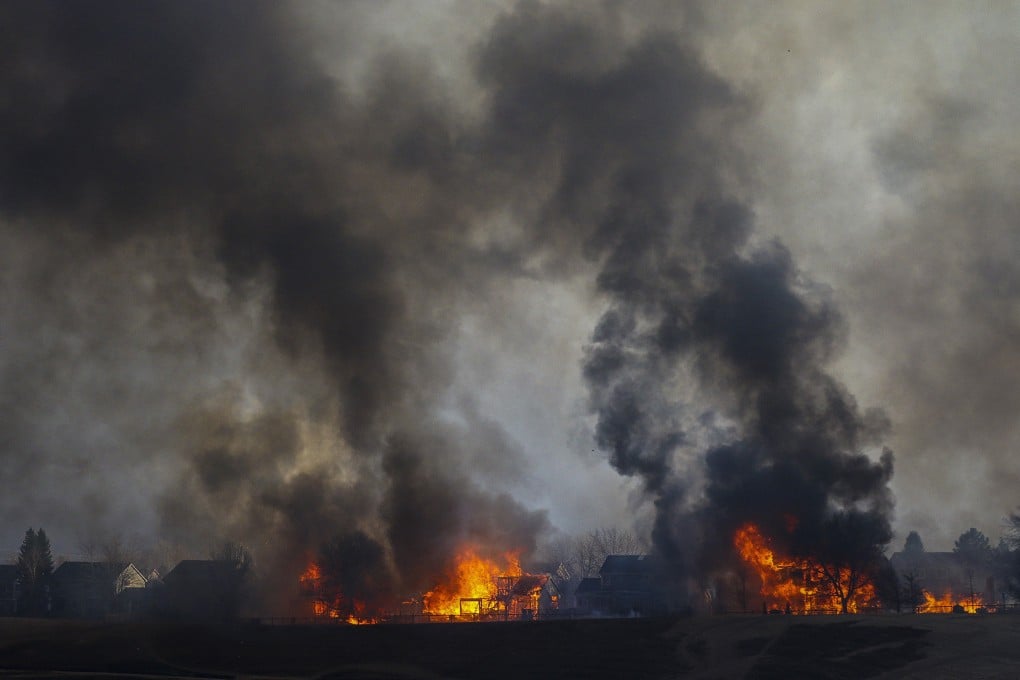 Two homes are seen in flames after wildfires swept through Louisville, Colorado, in December. Photo: TNS