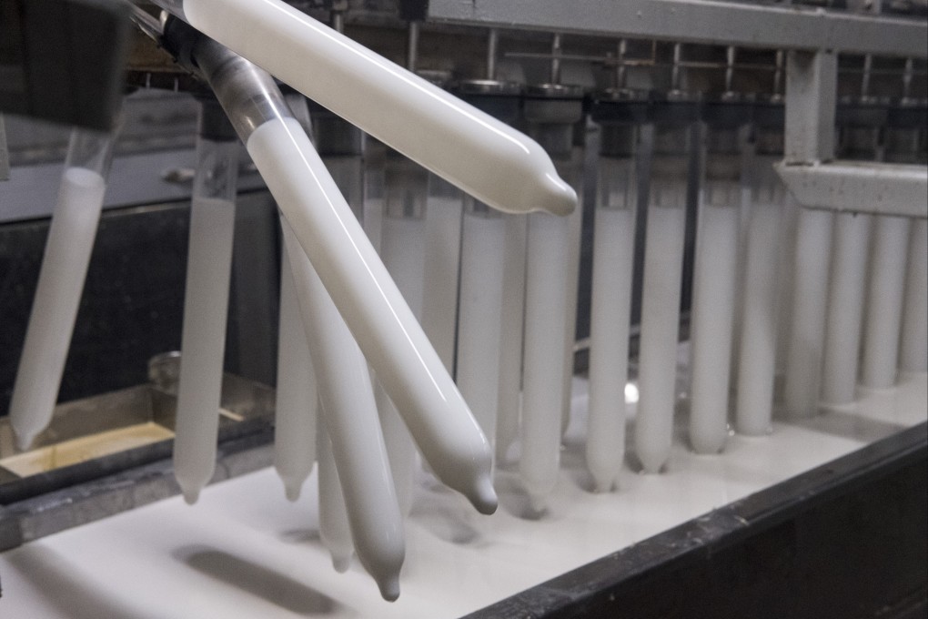Condoms are dipped into latex tanks on the production line at Karex. Photo: Alexandra Radu