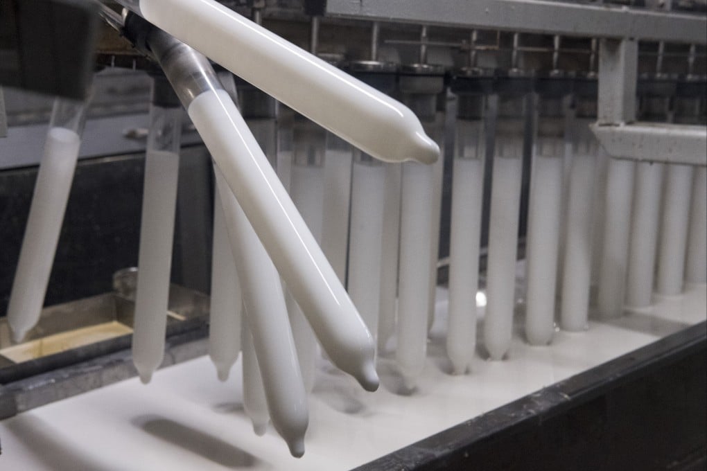 Condoms are dipped into latex tanks on the production line at Karex. Photo: Alexandra Radu