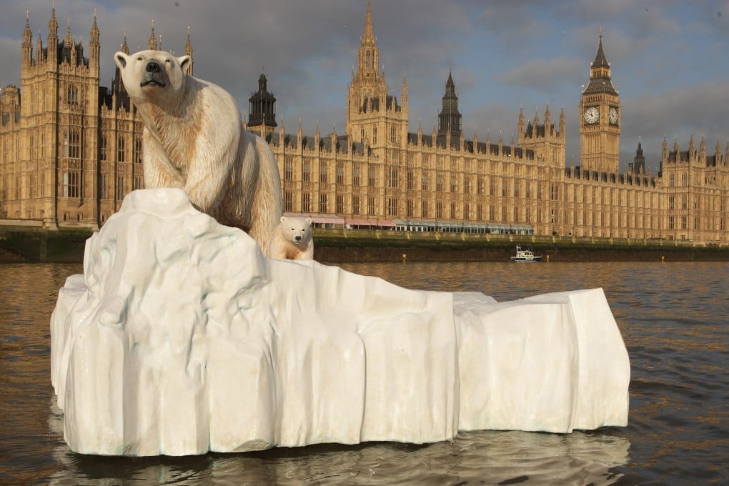 A five-metre (16 ft) high sculpture of a polar bear and cub, afloat on a small iceberg, passes in front of the Houses of Parliament in London to alert lawmakers to the dangers of climate change. Photo: Getty Images