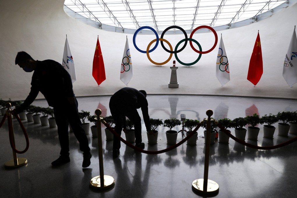Staff prepare a security barrier in front of a display of the Olympic flame for the Beijing 2022 Winter Games. Photo: Reuters